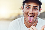 Fashion, city and portrait man with tongue out enjoy weekend, summer vacation and holiday. Freedom, comic and young male with funny face expression listening to music, radio and audio in urban town