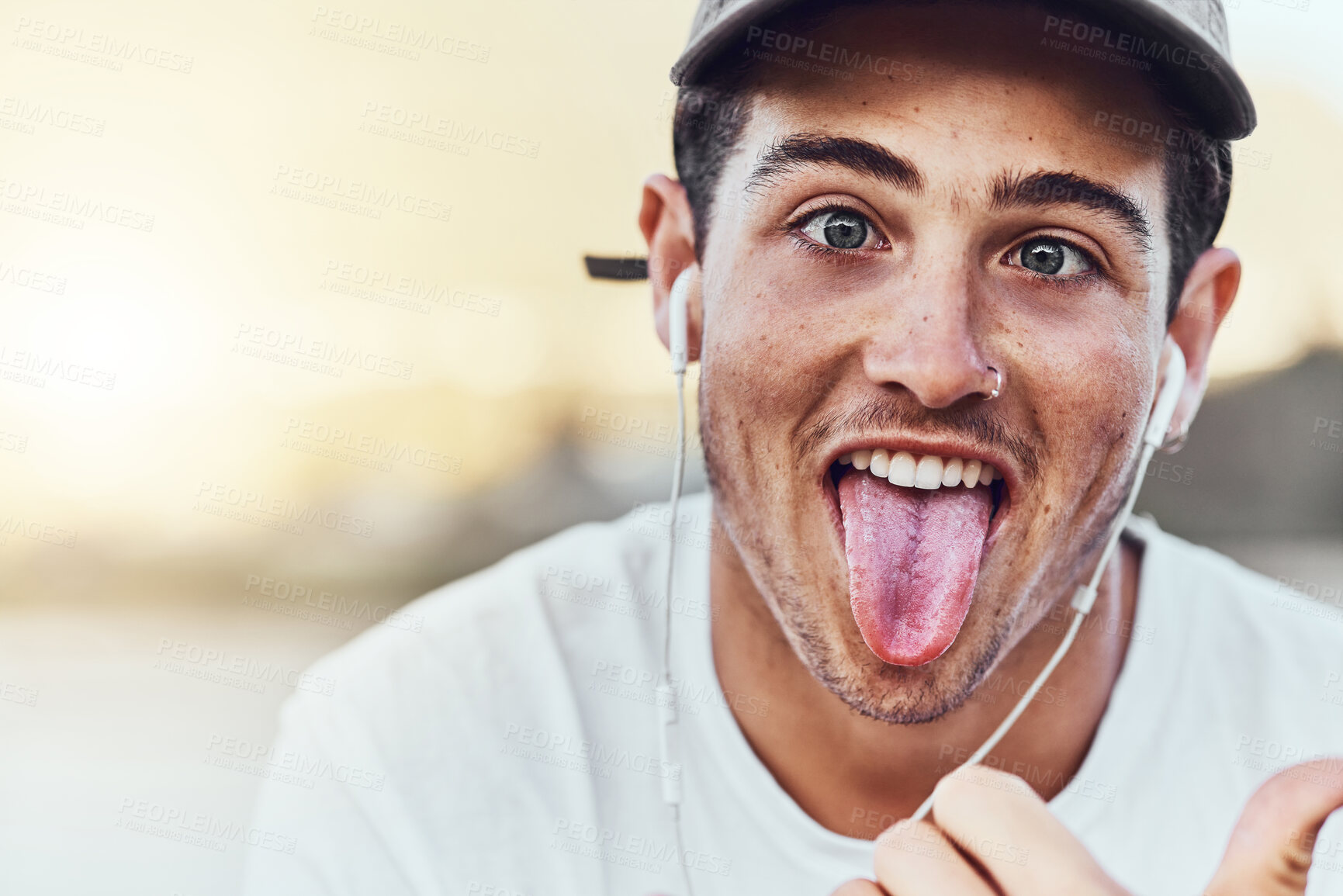 Buy stock photo Fashion, city and portrait man with tongue out enjoy weekend, summer vacation and holiday. Freedom, comic and young male with funny face expression listening to music, radio and audio in urban town