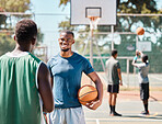 Basketball, sports and talking with black man friends on a court before a competitive game together. Fitness, team and exercise with a male basketball player and friend chatting before sport training