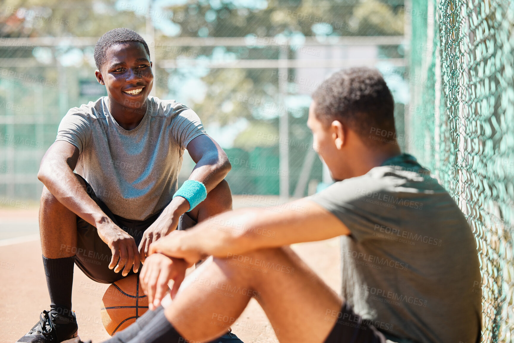 Buy stock photo Basketball, sport and athlete friends talk after training, exercise and sports outdoor. Game conversation on the basketball court ground talking about team strategy on a relax break from fitness