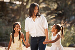 Family, children and holding hands with a mother and daughter siblings walking outdoor together in nature. Kids, love and happy with a woman, girl and sister taking a walk hand in hand while bonding