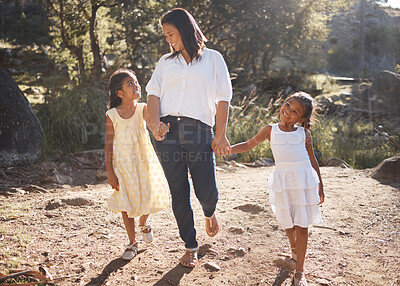 Buy stock photo Mother and children holding hands while walking in nature on adventure, hiking or family bonding trip on mothers day. Woman outdoor at park for travel with daughters or girl kids for love and support