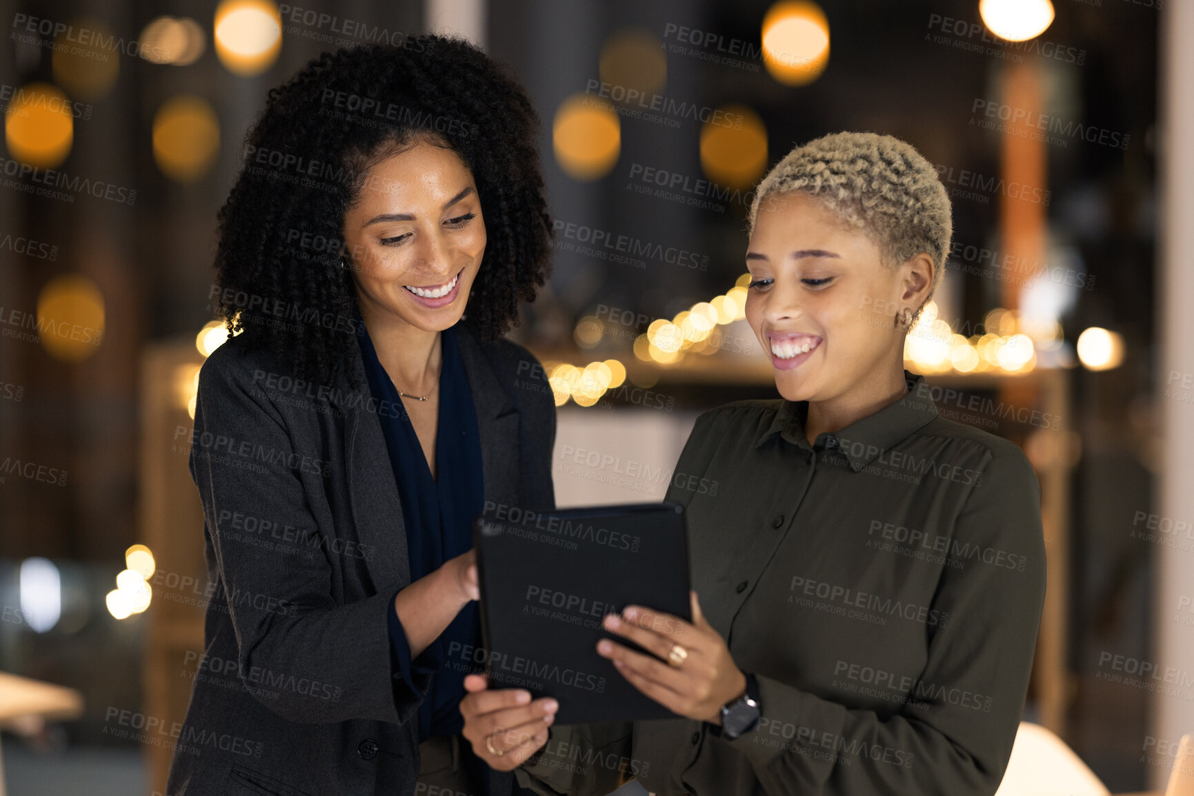 Buy stock photo Tablet, black woman and social media manager at a digital marketing agency coworking on a branding strategy. Night, teamwork and happy women reading a blog article on a copywriting social network