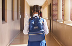 Girl student, backpack and walking in a school ready for study, education and morning class. Young students back view walk in a hall about to learn and study on campus for youth knowledge development