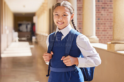 Buy stock photo Education, school and portrait girl in a uniform with a backpack standing in the hallway for class. Happy, smile and child student in the corridor for classroom to learn or study knowledge at campus.