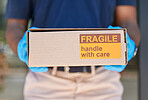Courier, delivery and box with label for fragile goods, handle with care and shipping closeup, safety and protection. Retail, ecommerce and online shopping, distribution of package and postal worker.