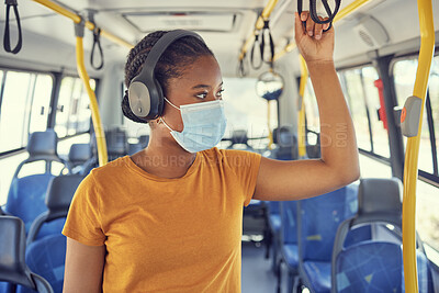 Buy stock photo Travel, face mask and woman on a bus with headphones to listen to music, radio or podcast on the trip. Journey, transport and African girl standing in vehicle with a mask for covid regulations safety