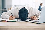 Tired businessman, sleeping and desk on notebook from burnout or overworked at the office. Exhausted male employee asleep holding pen during writing, working or documents suffering from work fatigue