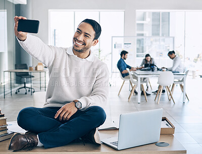 Buy stock photo Selfie, phone and businessman sitting on desk in meeting with team, staff and working in corporate office. Startup, happiness and young Asian male worker using smartphone to take picture in workplace