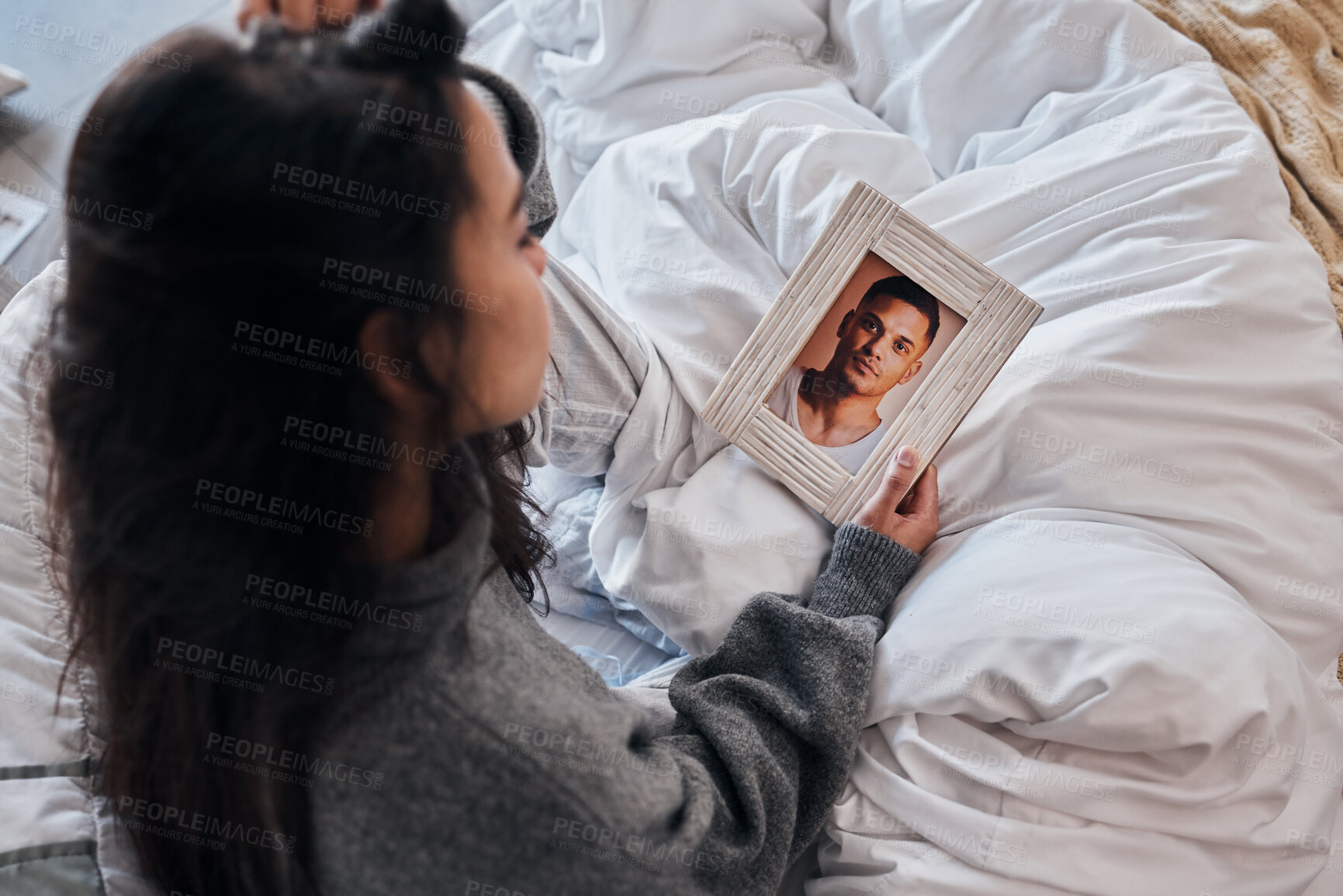 Buy stock photo Woman, sad and photo for widow on bed after death, funeral or loss of husband, partner or man. Grief depression, girl and picture memory of love, marriage or anxiety in home bedroom for mental health