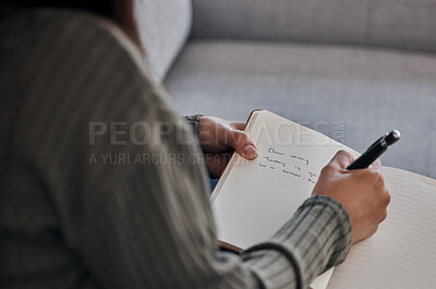 Buy stock photo Hand, book and woman writing in journal on a sofa for planning, brainstorm and feeling log closeup in a living room. Notebook, diary and girl with mental health problem write note on emotions in home