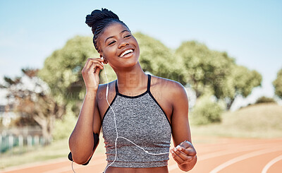 Buy stock photo Earphones, fitness and black woman running on a track for marathon, race or competition training. Sports, workout and athlete runner listening to music, radio or podcast while doing cardio exercise.