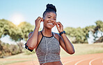 Running, portrait of woman on track with headphones and phone for fitness app on happy workout. Technology, sports and black woman runner with smile streaming music on run for health and wellness.