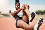 Black woman, runner stretching and training for race on racing track in stadium with focus, determination and motivation. Outdoor fitness workout, running sports exercise and athlete stretch on floor