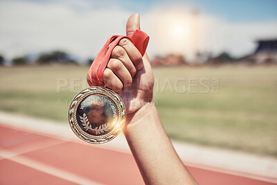 Buy stock photo Closeup, hand and medal for winning, success on track for marathon for wellness, outdoor and sports. Victory, athlete and winner holding gold award, achievement and competition for goal and champion.