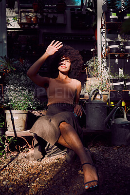 Buy stock photo Sun, shadow and light with beauty woman, garden and relax during summer, happy smile and afro in backyard outdoor. Latino female, fashion and relaxing in sunlight, gardening shed and pot plants