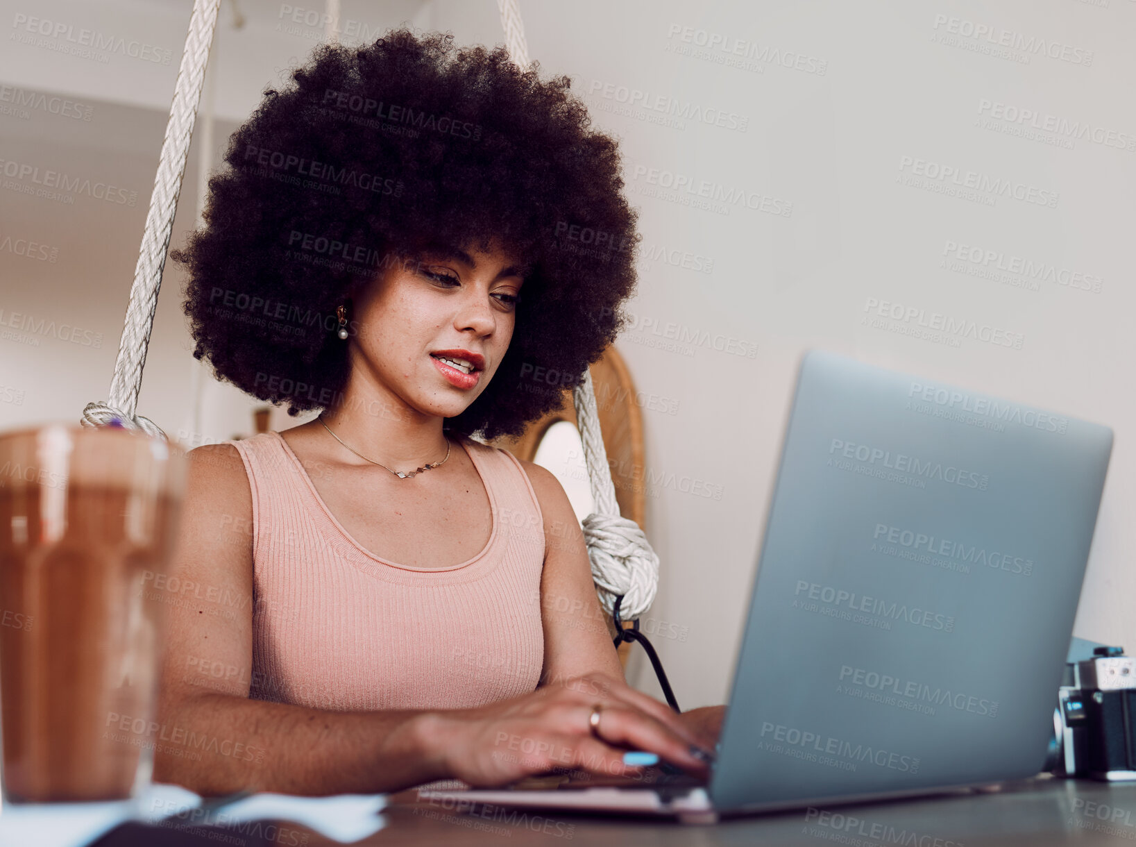 Buy stock photo Black woman afro, laptop and designer working, studying or typing email in remote work at home. Stylish African American female freelancer busy on computer in design course or business research