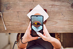 Woman, phone screen and taking photograph of coffee shop, restaurant and bistro for social media post, influencer food review and social network blog. Above of girl, smartphone and cafe drink picture