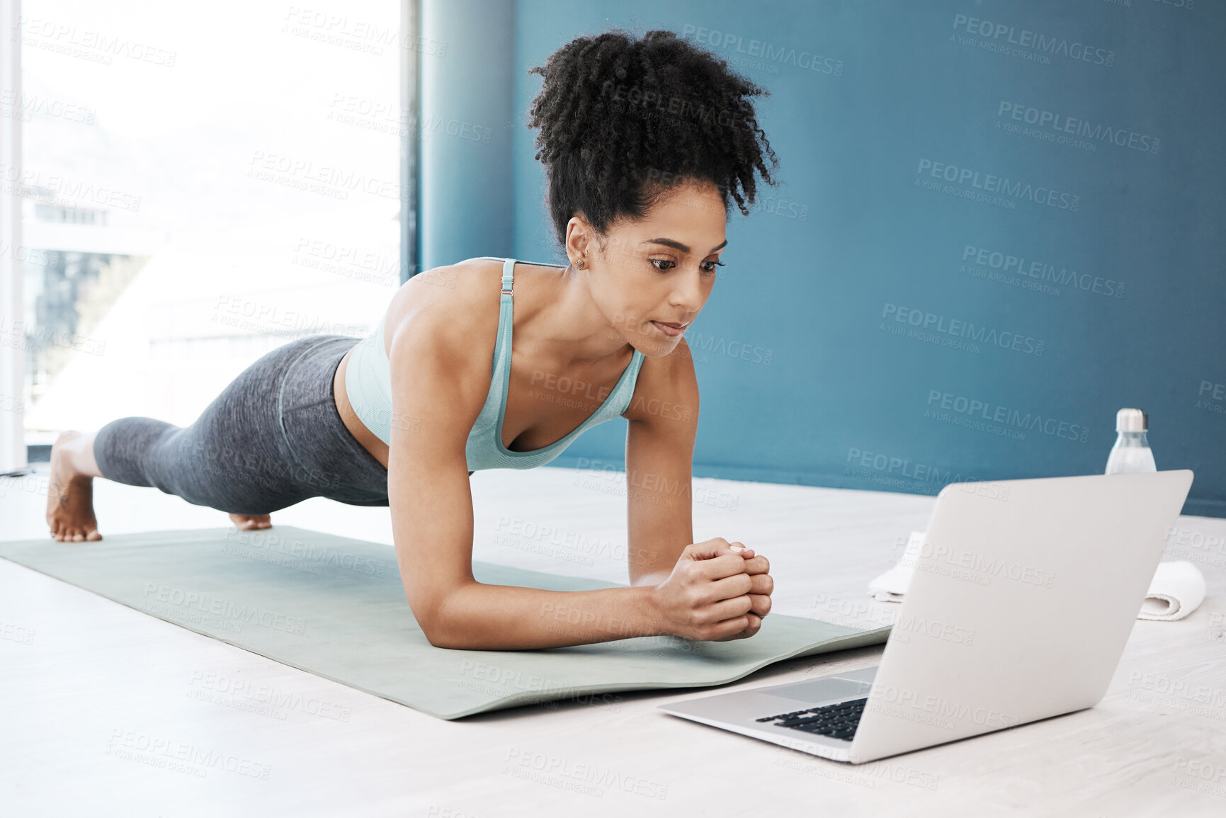 Buy stock photo Wellness, fitness and yoga webinar on laptop for healthy and young black woman in body plank position. Focus, balance and online mindfulness in exercise class with girl on floor in home for health.

