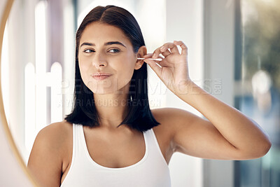 Buy stock photo Beauty, hygiene and ear cleaning with a woman using an earbud in the bathroom mirror of her home. Health, wellness and grooming with a female using a cotton bud to clean her eyes in the house