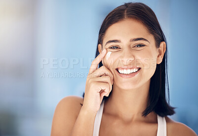 Buy stock photo Face, beauty and skincare with a woman in the bathroom applying lotion or moisturizer to her face. Portrait, cosmetics and skin with an attractive young female using cream for hydration at home