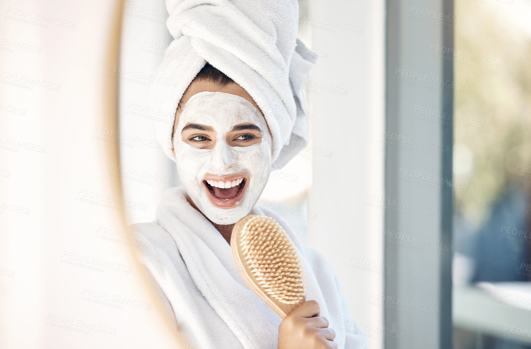 Buy stock photo Woman, face mask and mirror with a brush for singing, beauty and home spa treatment in bathroom with a towel and bathrobe. Face of happy female doing facial for self care and detox with cosmetics