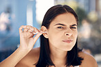 Ear, cleaning and woman in a bathroom for grooming, hygiene and daily routine with cotton buds on blurred background.  Face, girls and earwax removal for wellness, gresh and body care in India
