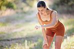 Fitness, woman and checking watch for running time, exercise or workout training in the nature outdoors. Active female runner looking at smart watch for monitoring or tracking cardio performance