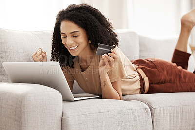 Buy stock photo Success, laptop and black woman with a credit card happy with digital payment notification while relaxing on a sofa at home. Smile, finance and African girl in celebration of online shopping discount