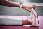 Fitness, feet and woman stretching, sneakers and legs on mat for sports training, exercise and yoga workout. Closeup of female athlete touching shoes, foot and warm up, wellness and healthy lifestyle