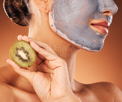 Buy stock photo Facial, mask and hand with kiwi for skincare of woman for wellness, beauty and self care routine. Cosmetic, spa and pamper lifestyle girl with natural treatment on brown studio background zoom.

