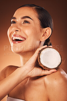 Buy stock photo Skincare, coconut and woman in studio happy to promote fruit diet benefits, beauty cosmetics or facial treatment. Smile, young or healthy woman marketing or advertising coconut oil for a glowing face