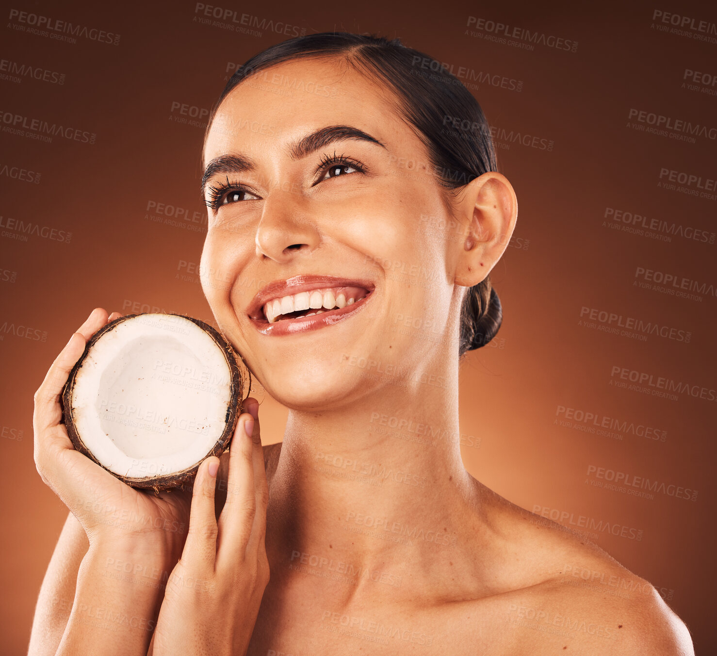 Buy stock photo Coconut, skincare and beauty woman marketing food, thinking wellness and spa facial against a brown studio background. Health, cosmetics and model with a natural oil product for skin glow and detox