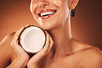 Beauty, skincare and coconut with a model woman in studio on a brown background for natural treatment. Spa, food and wellness with a young female ready to promote a health product for skin care