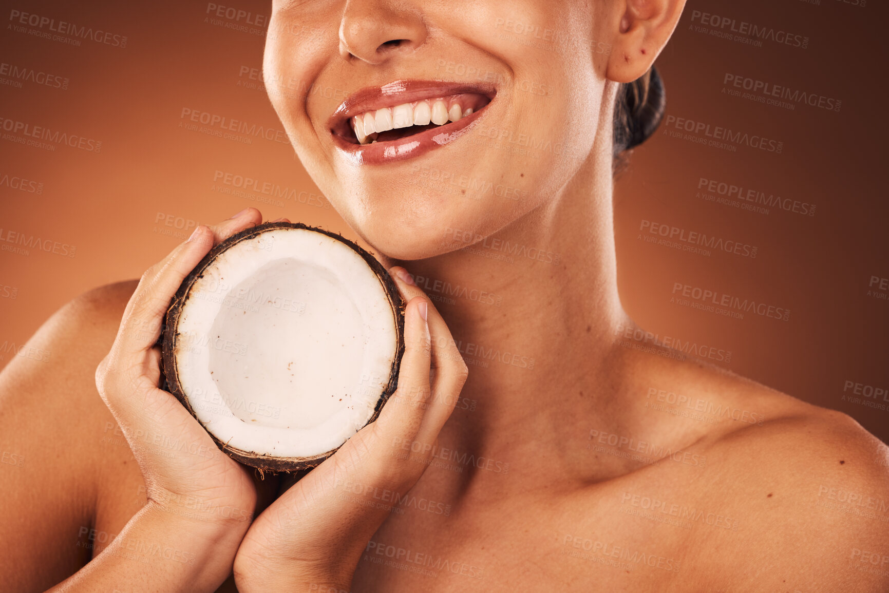 Buy stock photo Beauty, skincare and coconut with a model woman in studio on a brown background for natural treatment. Spa, food and wellness with a young female ready to promote a health product for skin care