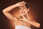 Beauty, skincare and kiwi fruit for health and wellness on studio background for dermatology treatment for a glow and happiness. Face of aesthetic model with makeup, cosmetics  and vitamins c product