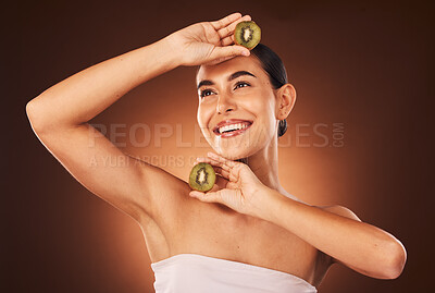 Buy stock photo Beauty, skincare and kiwi fruit for health and wellness on studio background for dermatology treatment for a glow and happiness. Face of aesthetic model with makeup, cosmetics  and vitamins c product