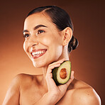 Beauty, wellness and woman in studio with avocado for diet, healthy eating and skin health on orange background. Skincare, girl and model with fruit, nature and product for cleaning, facial and mask