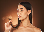 Beauty, woman and hair check for growth of split ends with worried, ponder and thinking face. Concerned skincare, body and hair care model with treatment problem on brown studio background.

