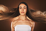 Hair care, beauty and woman cosmetics, makeup and shampoo advertising or marketing in brown studio background. Model, long hair and portrait with wellness, self love and self care for facial cosmetic