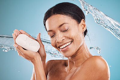 Buy stock photo Water splash, happy and black woman with soap for skincare, self love or self care in studio on blue background. Hands, shower and healthy African girl washing, grooming or cleaning her face or body 
