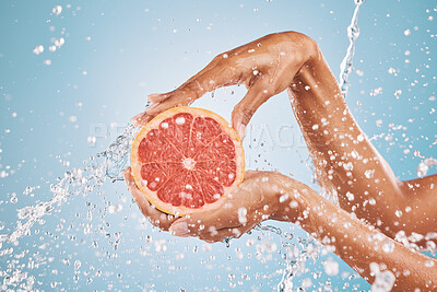 Buy stock photo Hands, water splash and grapefruit cosmetic skincare for vitamin c nutrition, citrus health treatment and natural wellness. Healthy skin hygiene, advertising hydration and a blue studio background 

