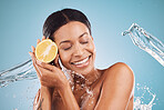 Lemon, skincare and black woman with a beauty water splash, product marketing and nutrition against a blue background in studio. Vitamin c, diet and model advertising fruit for health of skin