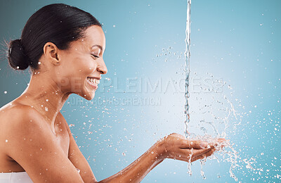 Buy stock photo Beauty, skincare and water splash on blue studio background with happiness for cosmetics, health and wellness for dermatology mockup. Face of model with hands and smile for clean skin and self care