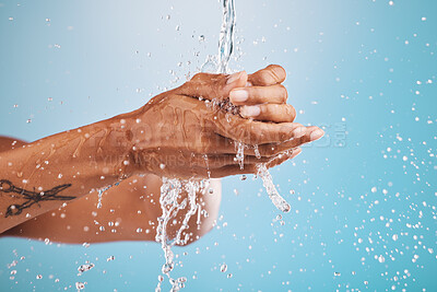 Buy stock photo Water, washing and cleaning hands on blue background for hygiene, healthcare and cleansing in studio. Wellness, hydration and person washing hands for germ protection, bacteria and safety from virus