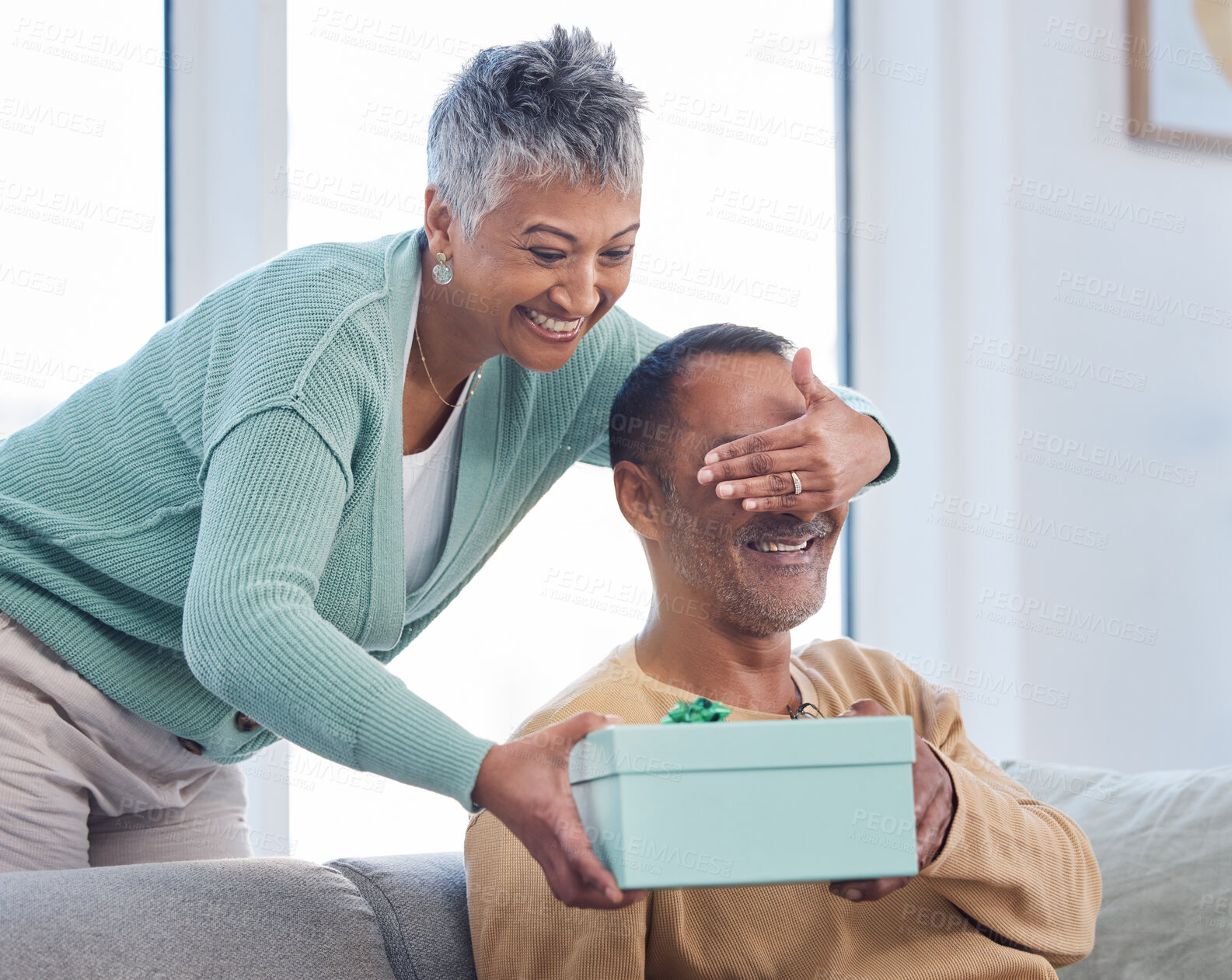 Buy stock photo Senior couple, gift and surprise in home living room with wife covering eyes of husband. Love, care and retired elderly man receiving box of presents from woman for Christmas or birthday celebration.