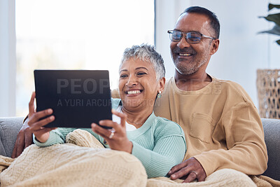 Buy stock photo Love, senior couple and tablet on sofa, social media or online reading together in lounge. Mature man, elderly woman or device to search internet, bonding or loving for video call, happiness or relax