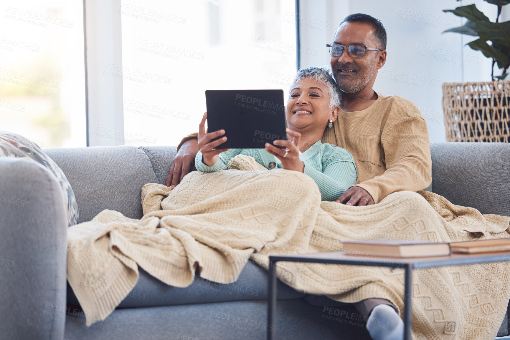 Buy stock photo Tablet, relax and movies with a senior couple on the sofa to relaxing while using an online streaming service. Happy, technology and internet with a mature man and woman under a blanket at home