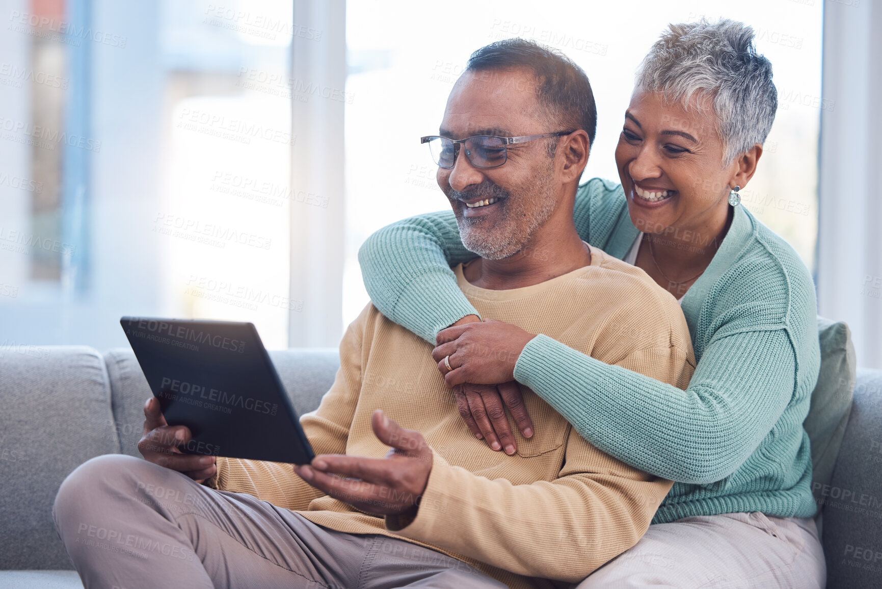 Buy stock photo Old couple, tablet and relax with hug on sofa, social media or streaming movie. Love, retirement and elderly man and woman hugging or embrace on couch in living room while internet browsing on tech.