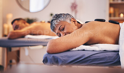 Buy stock photo Spa, couple and relax stone massage in wellness, luxury zen therapy and skincare beauty. Senior woman, man sleeping and healthy body detox for peace, calm and holistic rock treatment at resort salon